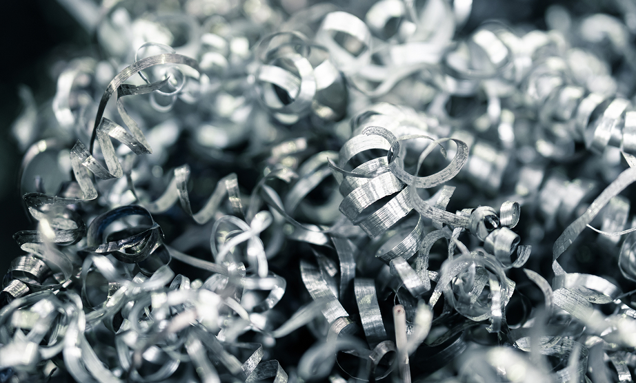 A close-up of metallic shavings, intricately curled and intertwined, reflecting light in various shades of silver.
