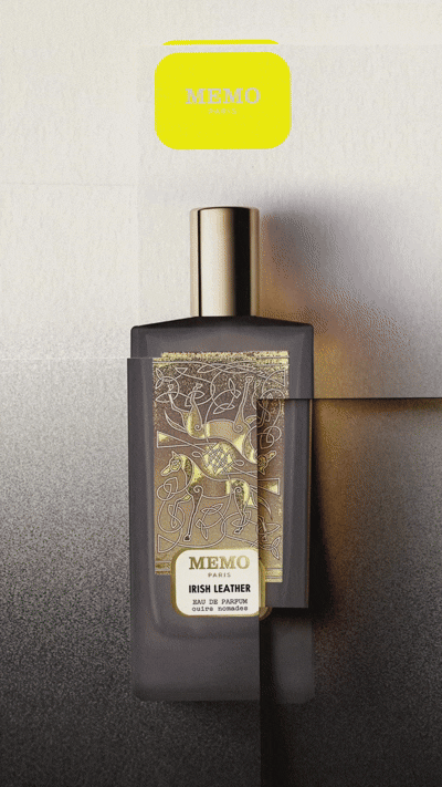 A black perfume bottle with ornate gold detailing labeled "MEMO IRISH LEATHER" against a gradient background, topped with a bright yellow cap.