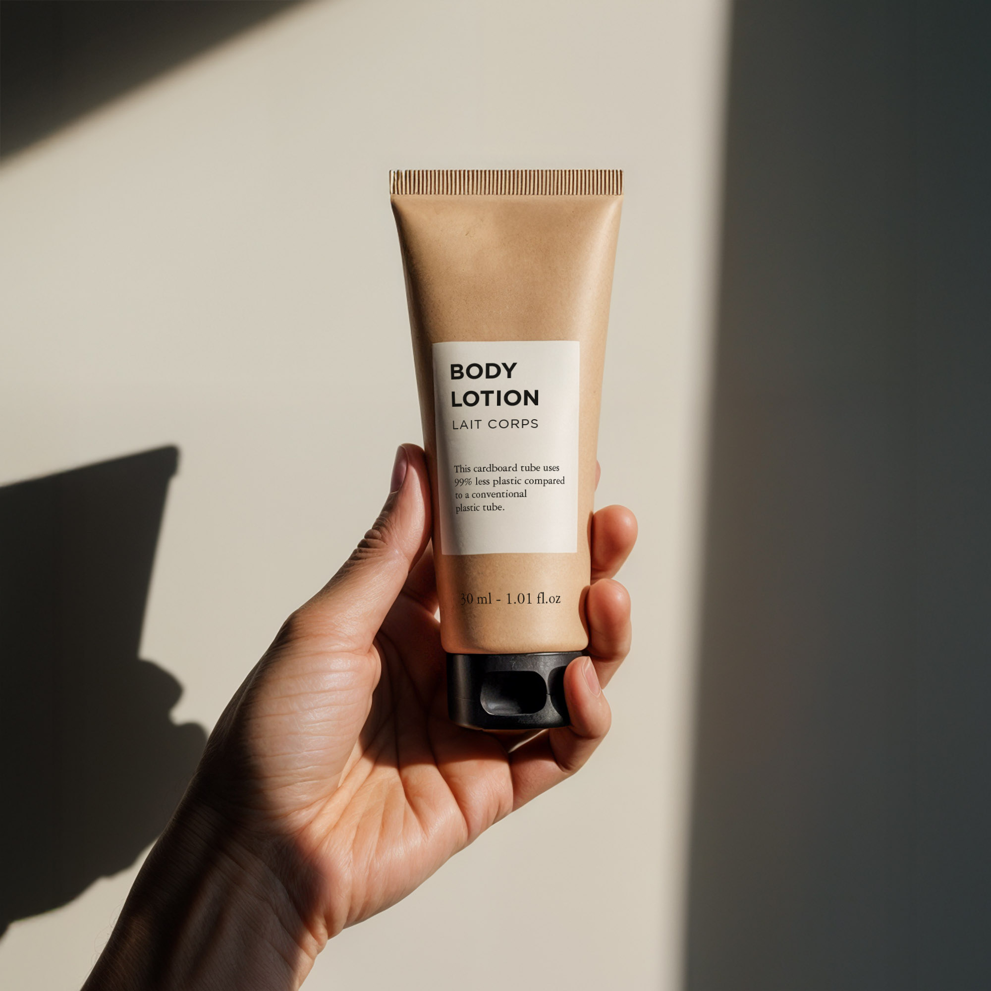 A hand holds a tube of body lotion with a minimalist design featuring a beige label and black text against a softly lit background.