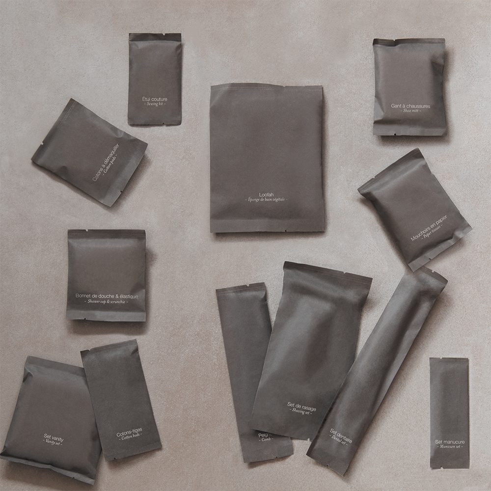 A collection of small, darkly packaged items arranged on a beige background, each labeled with white text indicating their contents.