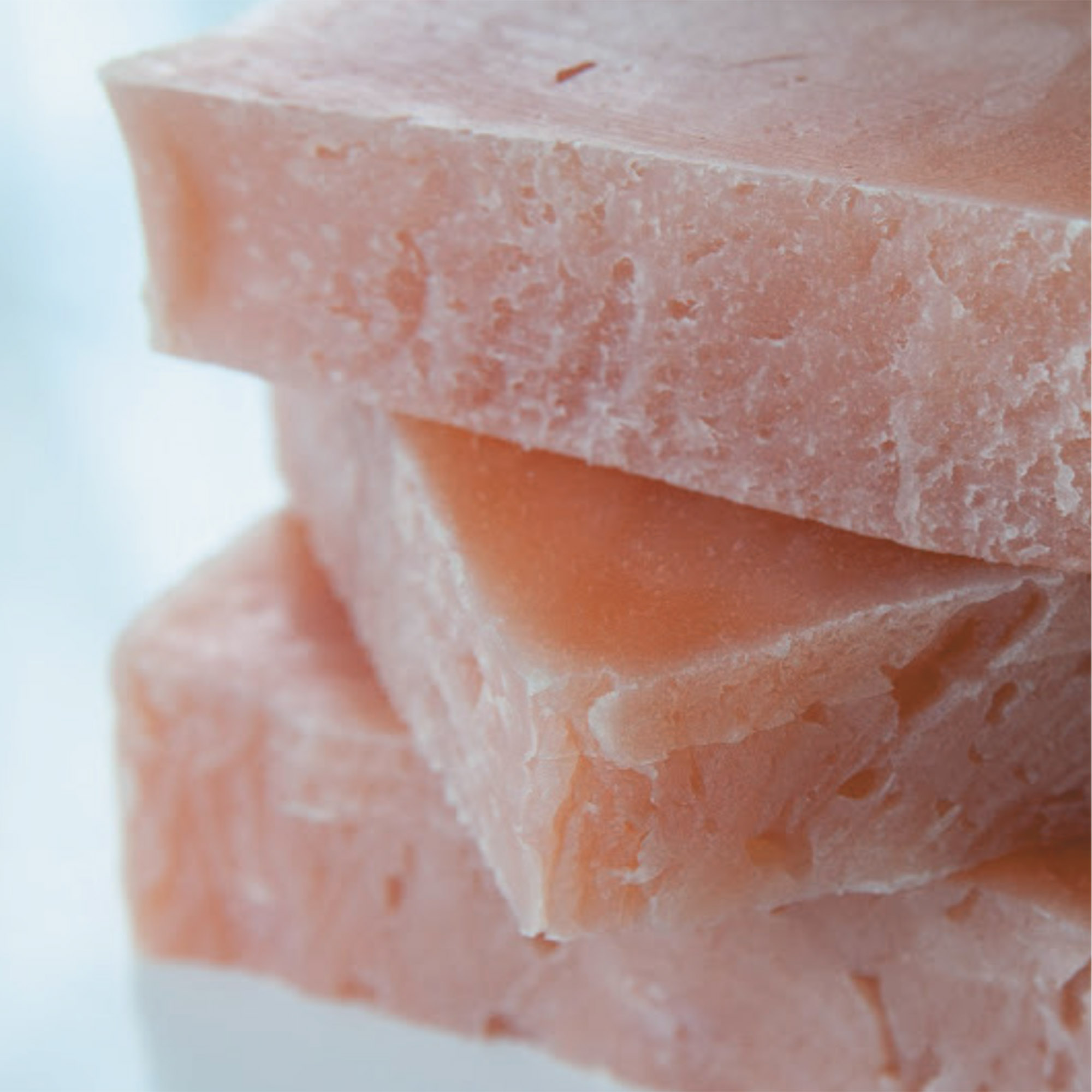 Three stacked slices of pink soap with a smooth, glossy surface.