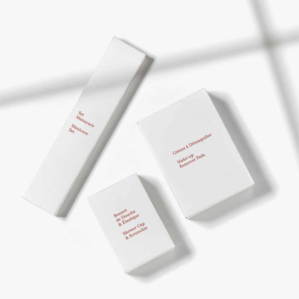 Three white boxes of skincare products arranged on a light surface, featuring minimalistic design and red text labels.