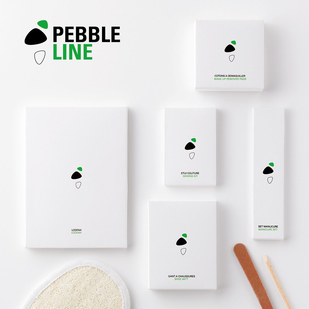 A collection of minimalist packaging for the "Pebble Line" brand, featuring simple white boxes and a notepad, each with a subtle green and black acorn logo. The items are arranged on a light background, emphasizing their clean design.