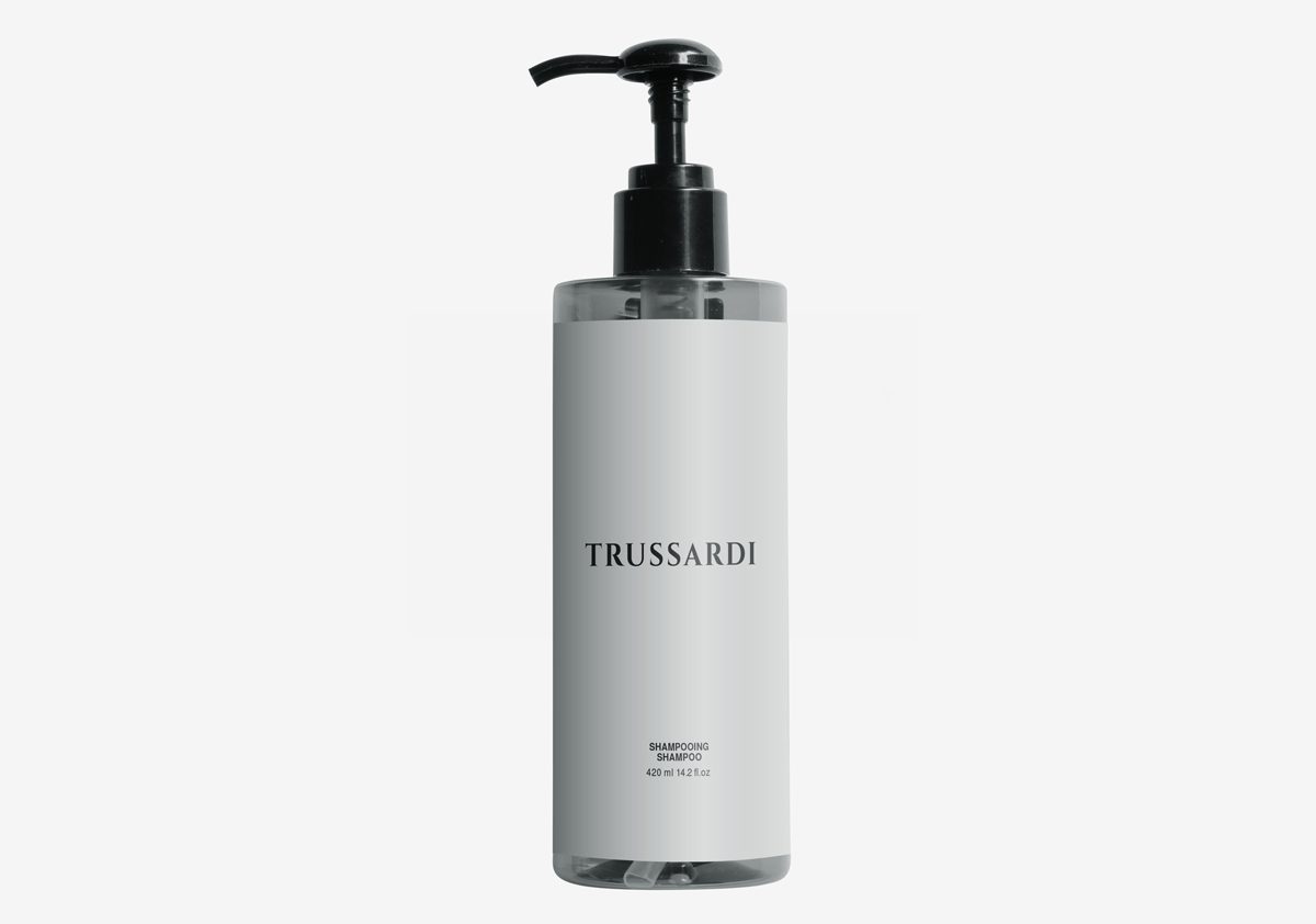 A clear shampoo bottle with a black pump top, featuring a minimalist design and labeled "TRUSSARDI" in bold letters.