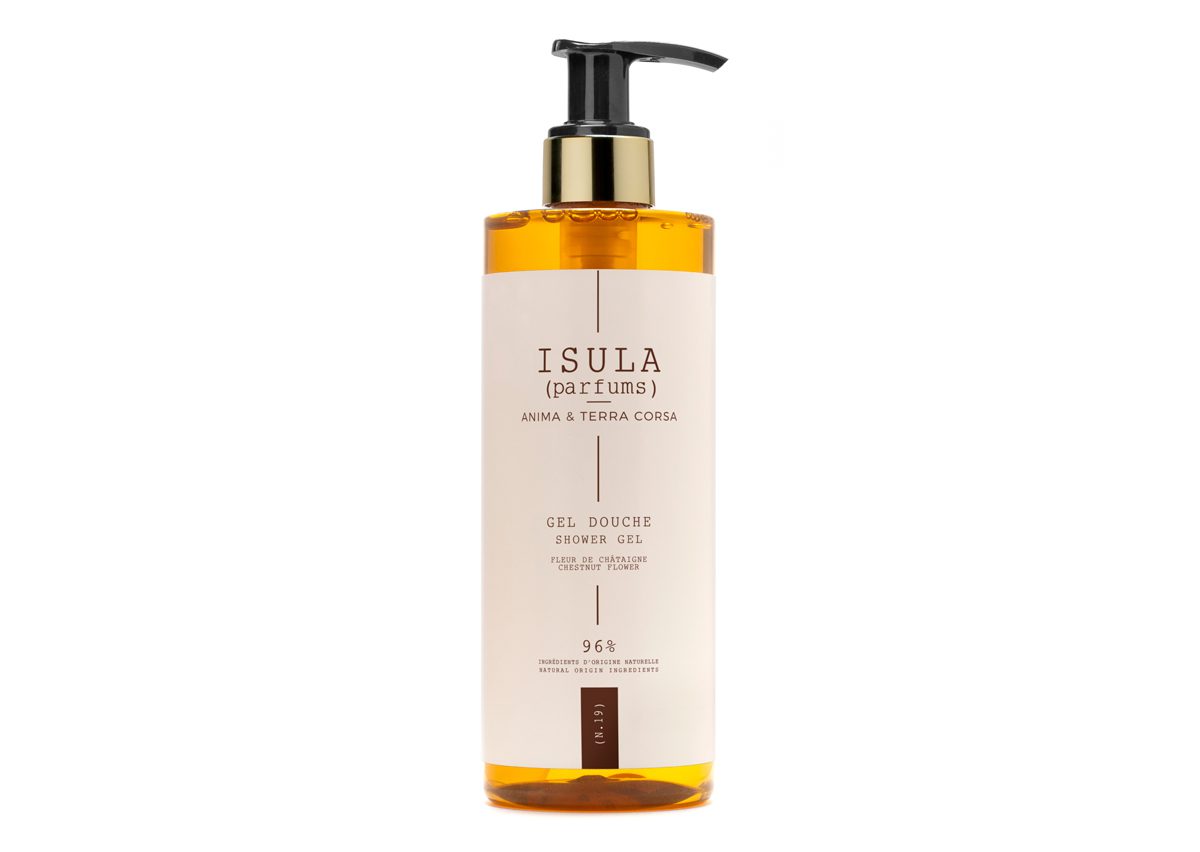 A clear bottle of ISULA shower gel with a black pump, featuring a minimalist label in white and beige that reads "ISULA (parfums) ANIMA & TERRA CORSO" and "Gel Douche Shower Gel." The liquid inside is amber-colored.