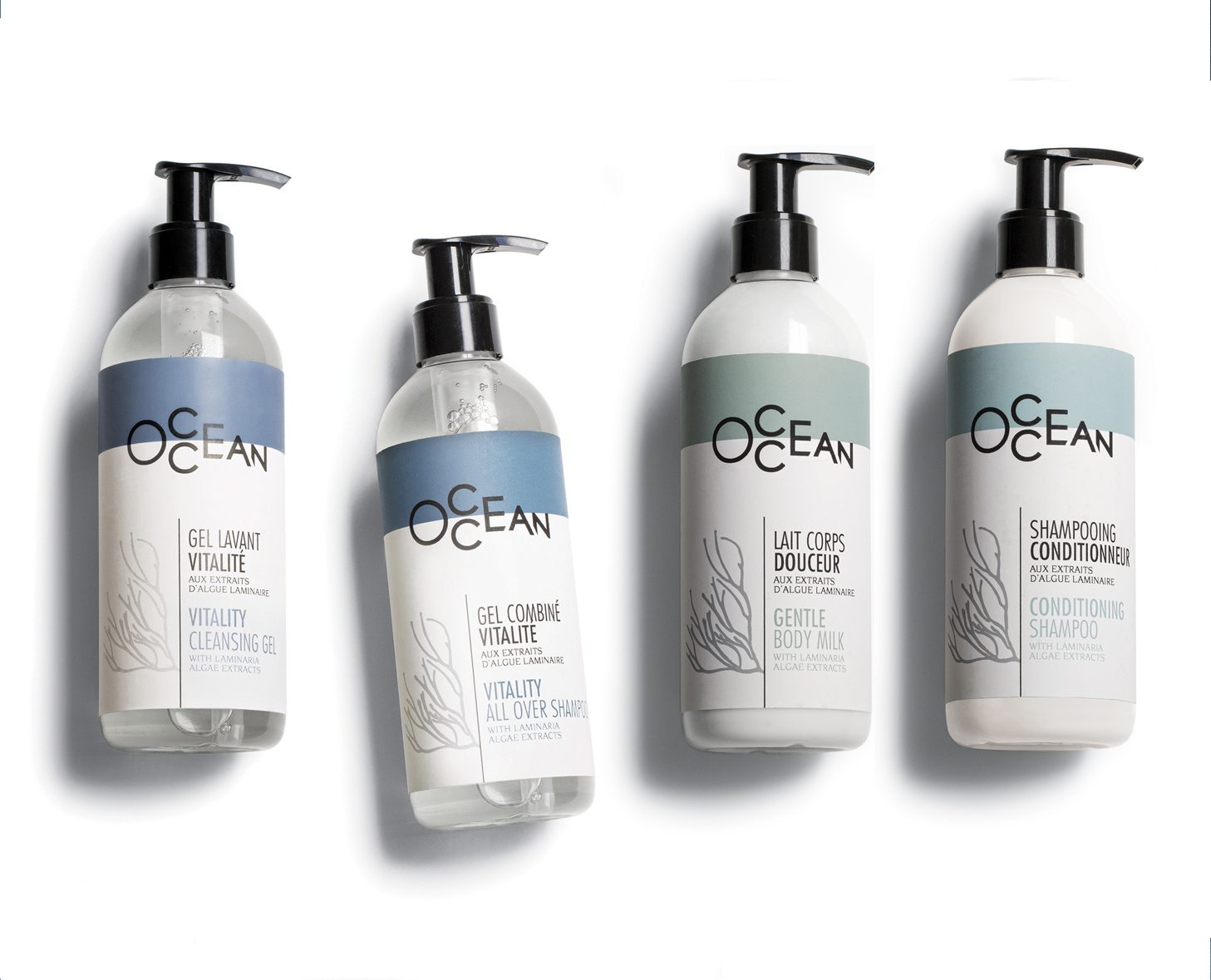 Four bottles of hair and body care products labeled "OCEAN," featuring a cleansing gel, all-over shampoo, body milk, and conditioning shampoo. Each bottle has a pump dispenser and a modern, minimalist design.