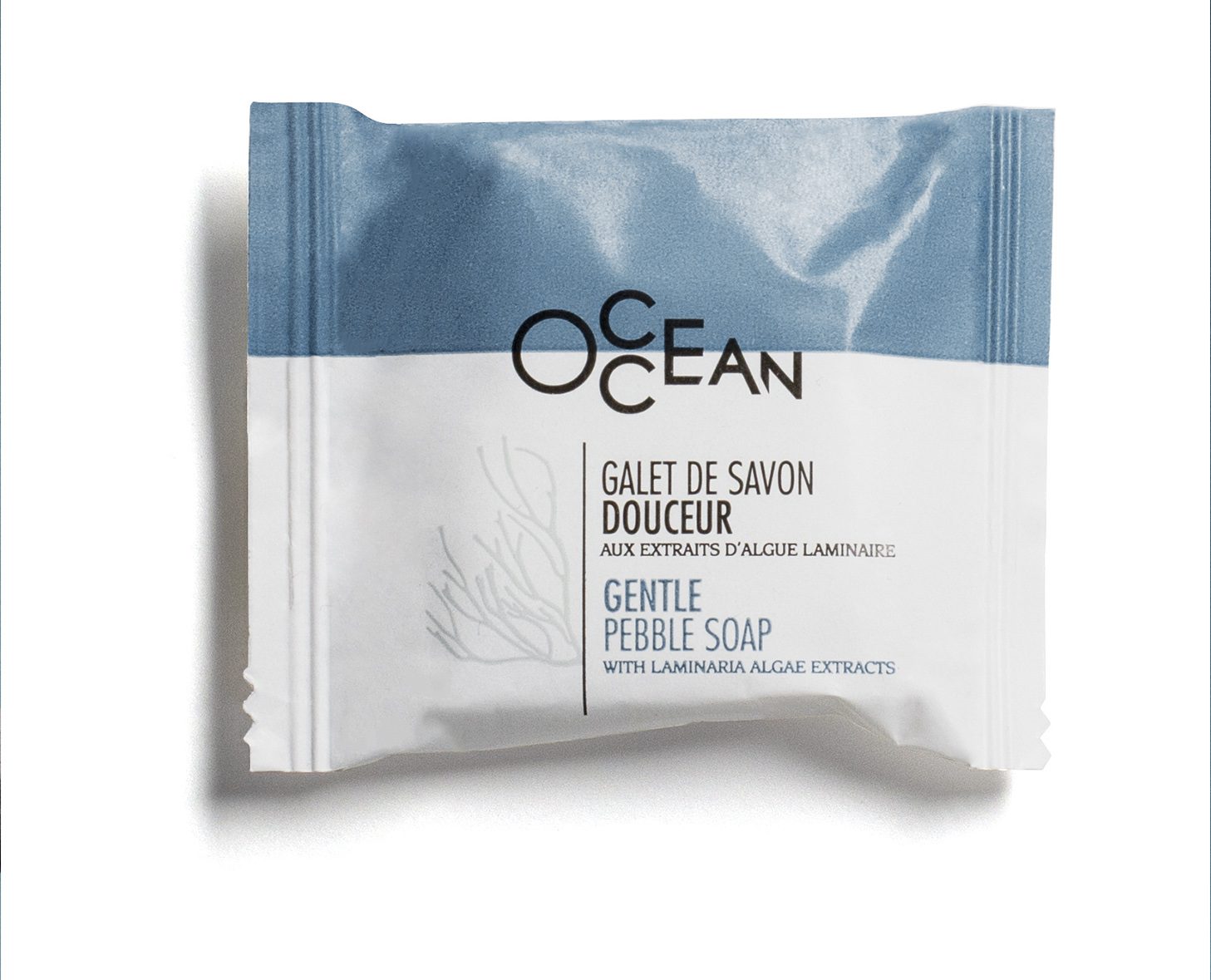 A packet of gentle pebble soap labeled "Ocean" with a blue and white design, featuring the text in both French and English. The soap contains extracts from Laminaria algae.