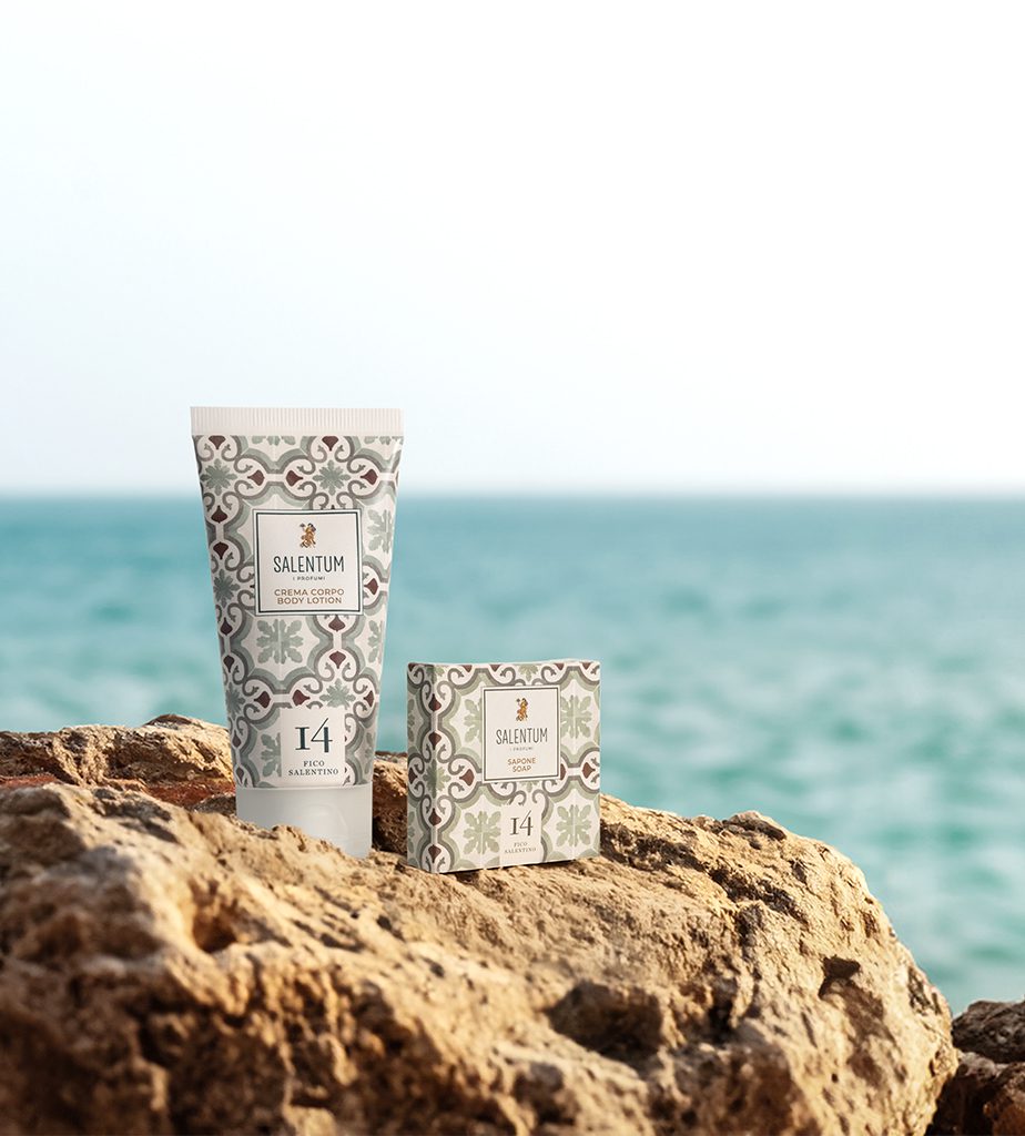 A tube of cream and a box of skincare product labeled "SALENTUM" are placed on a rock by the sea, with a soft focus on the water in the background.