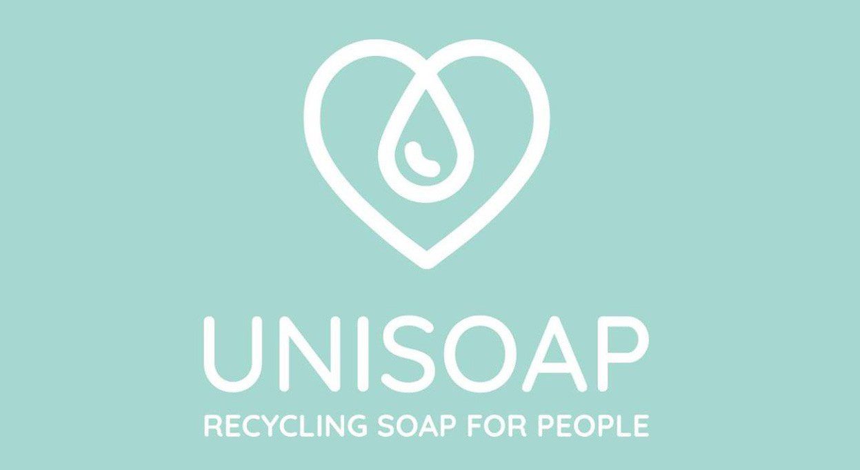 Logo for Unisoap featuring a heart shape with a water droplet inside, accompanied by the text "RECYCLING SOAP FOR PEOPLE" below it. The background is a soft turquoise color.