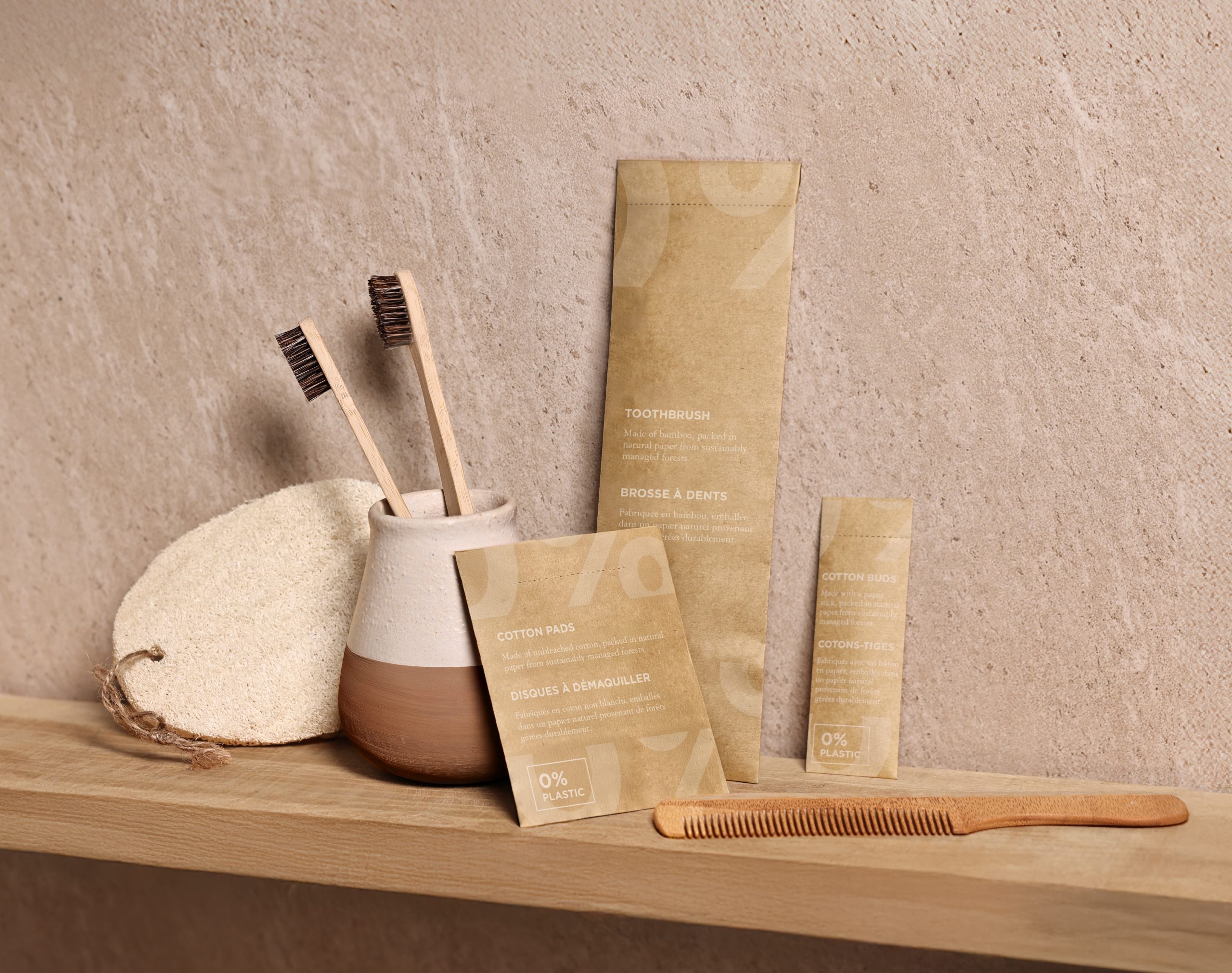 Eco-friendly bathroom amenities including bamboo toothbrushes, wooden comb, cotton pads and cotton buds in 0% plastic packaging