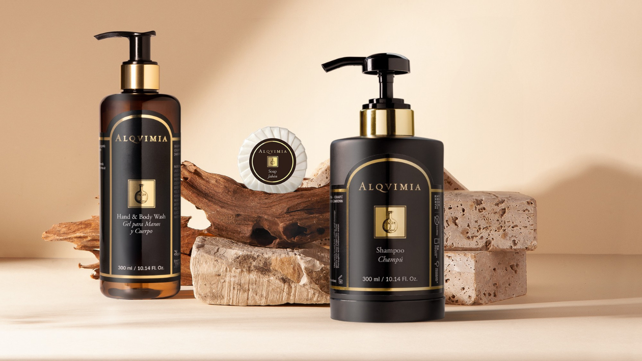 Alqvimia spa products including shampoo, hand and body wash, and soap displayed with natural stone and wood decor