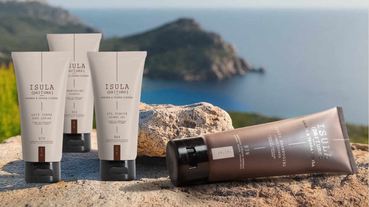 Isula Parfums body care products including shampoo, shower gel, lotion and conditioner displayed on rocks with sea view