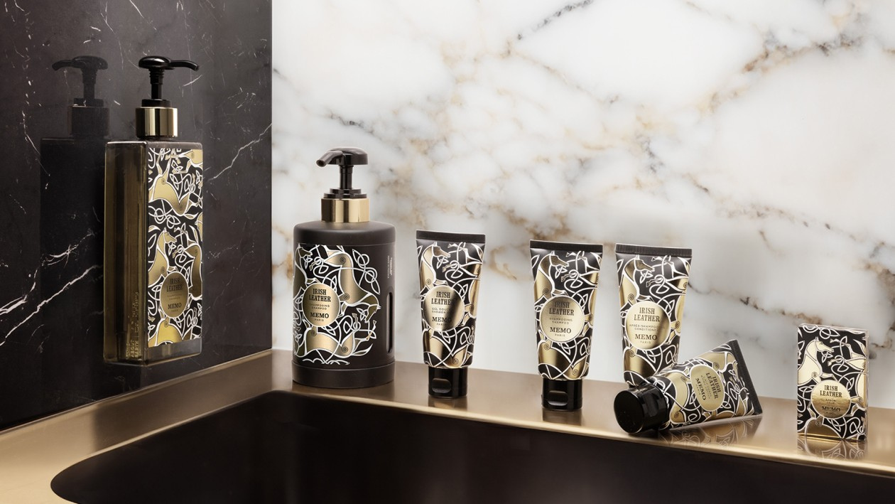 Memo Paris Irish Leather hotel amenities including body lotion, shampoo, conditioner and soap displayed on marble bathroom counter