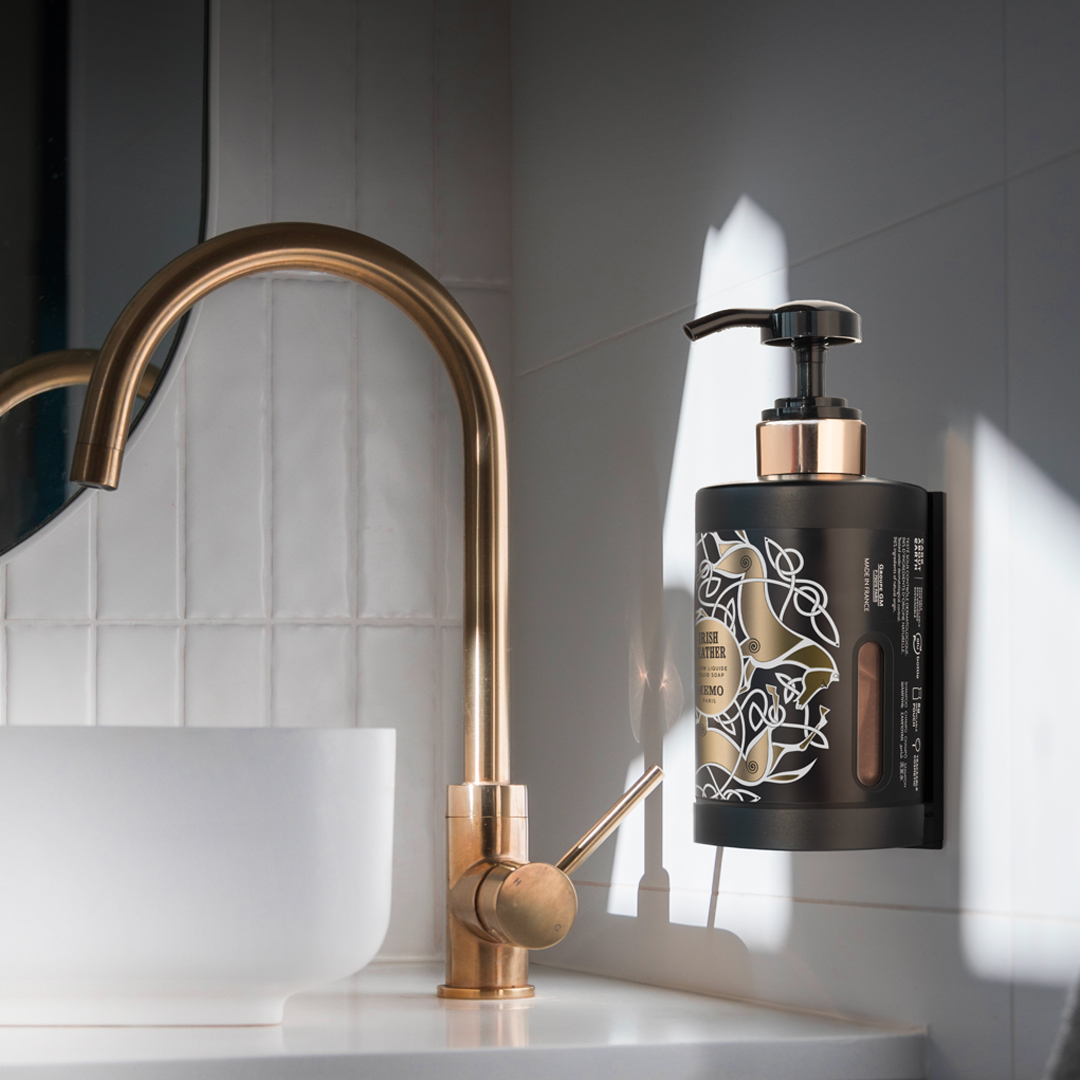Memo Paris Irish Leather wall-mounted hand wash dispenser next to gold faucet