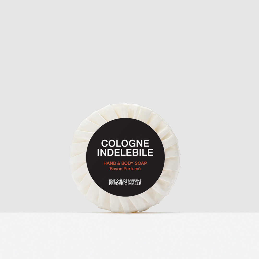 Wrapped Cologne Indélébile hand and body soap displayed against a light neutral background, featuring a pleated white wrapper and a black circular label with white and red text.