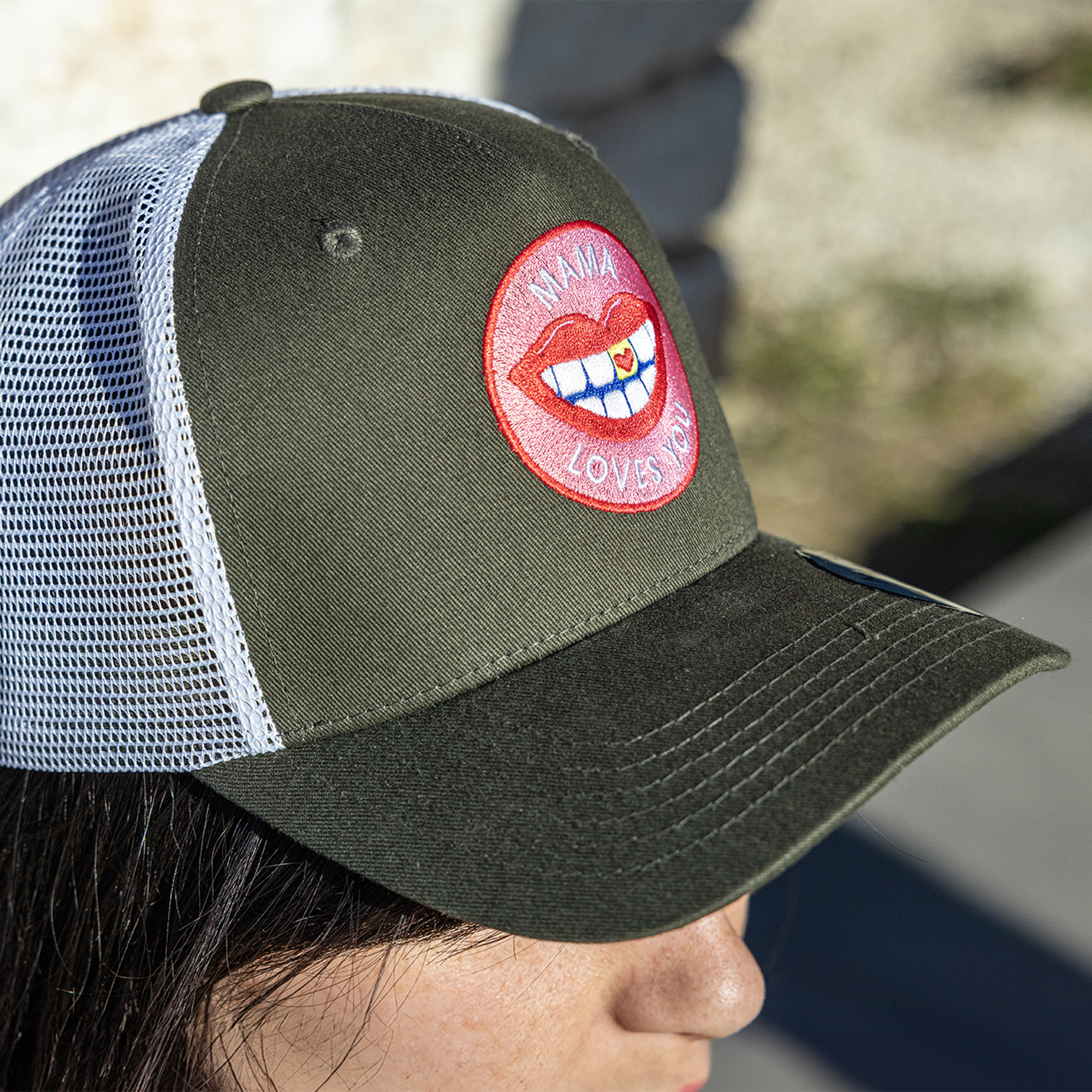 Olive-green trucker cap with an embroidered circular logo.