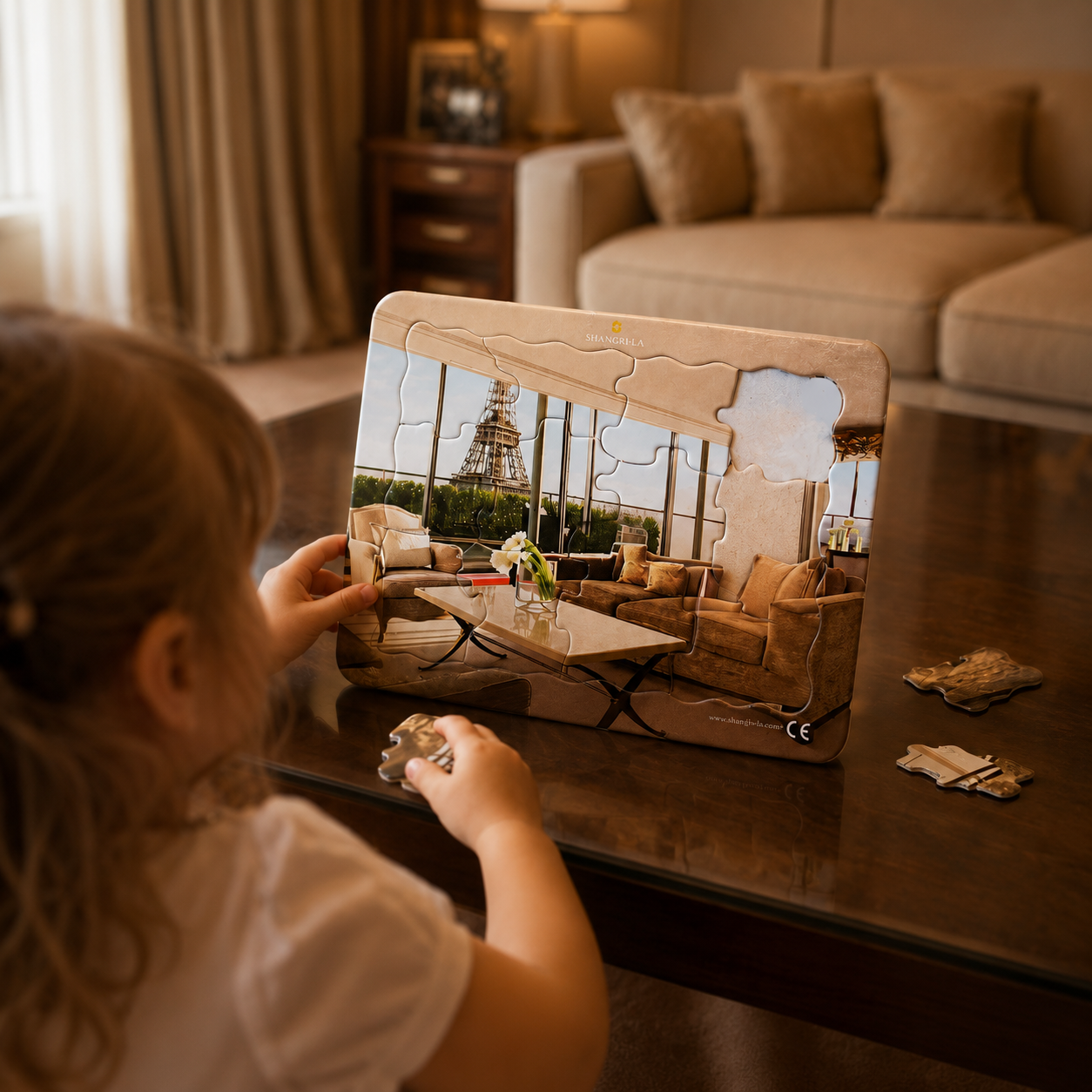 Child assembling a branded jigsaw puzzle on a coffee table in a hotel lounge.