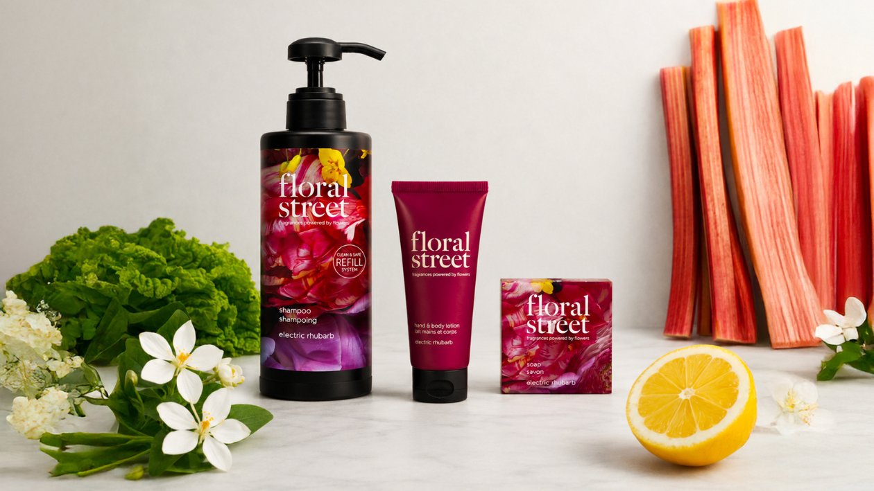 Floral Street Electric Rhubarb bath and body products including refillable shampoo, hand and body lotion, and soap, styled with fresh rhubarb stalks, white flowers, green leaves, and lemon on a clean background.