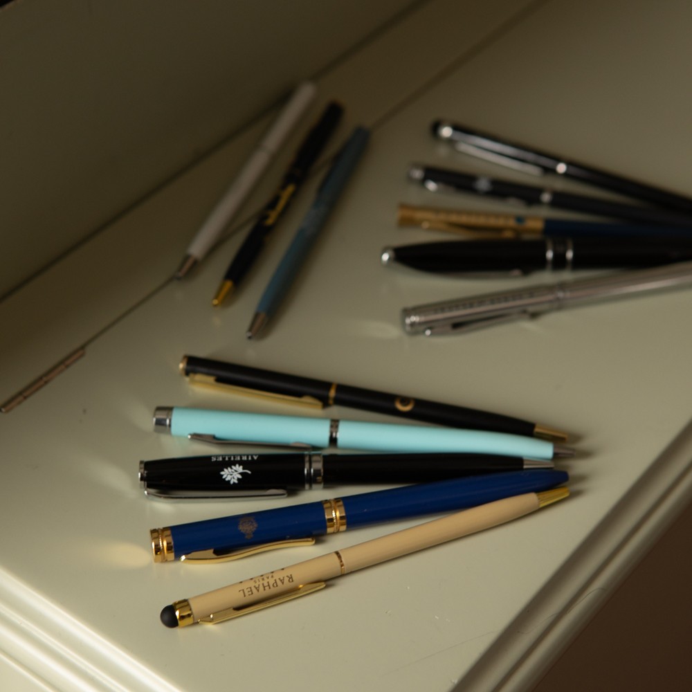 Selection of branded ballpoint pens displayed on a tabletop.