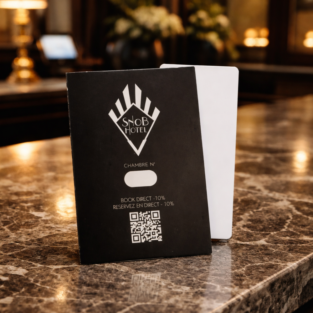 Branded hotel key card holder with QR code on reception desk.