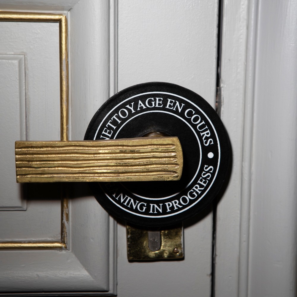 Cleaning-in-progress door hanger attached to a hotel room door handle.