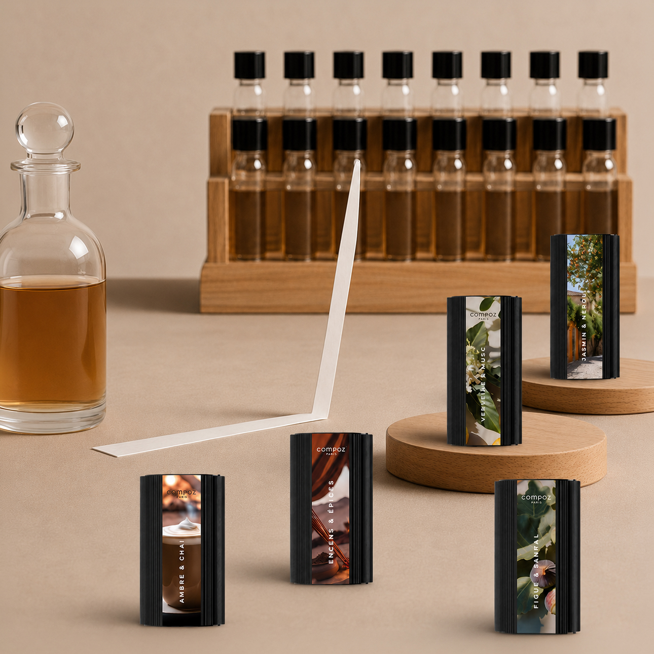Collection of Compoz Paris fragrance capsules displayed on wooden stands, alongside perfume bottles and scent strips in a perfumery-inspired setting.