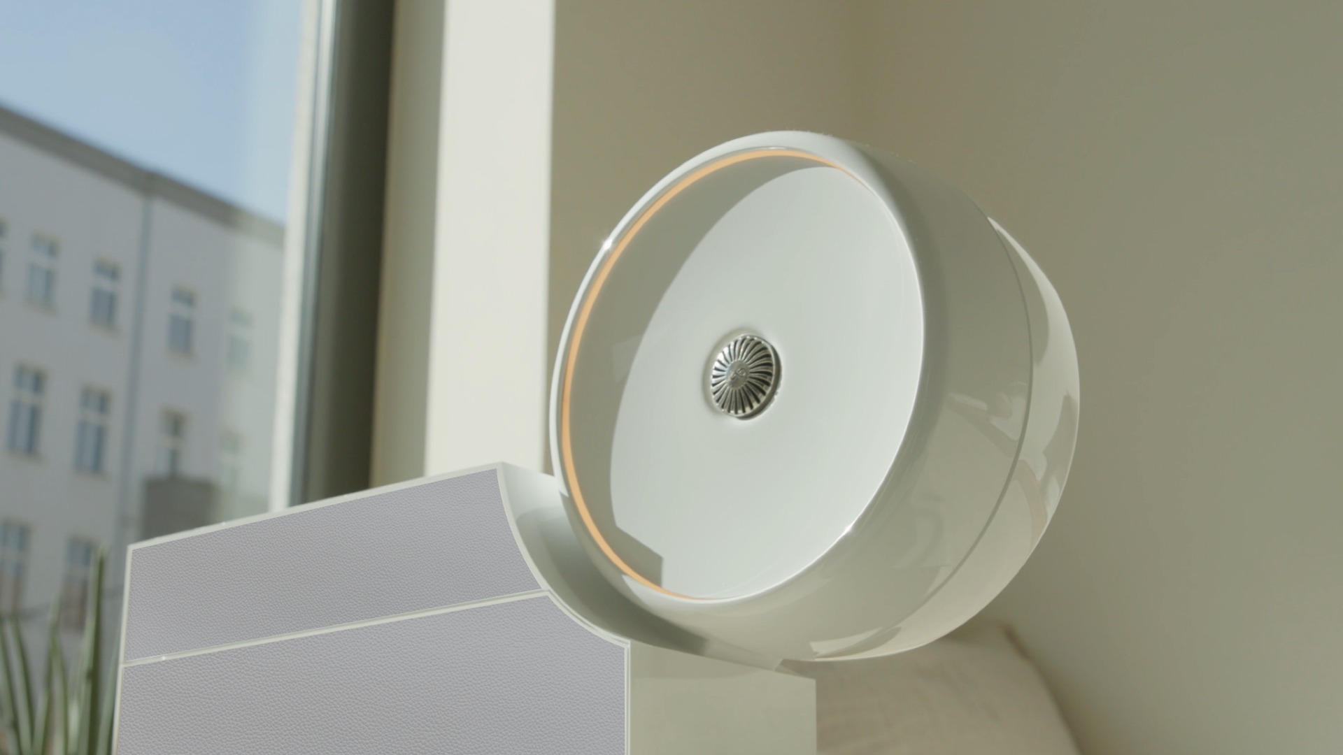 Modern smart fragrance diffuser mounted on a wall, featuring a sleek white design and ambient light for luxury home and hospitality fragrance experiences.